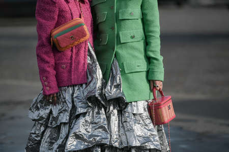 Paris, France â March 3, 2020: Women wearing pink and green blazers, silver ruffled maxi dresses and Chanel bags - streetstylefw20のeditorial素材
