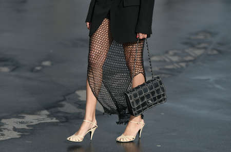 Paris, France â March 3, 2020: Woman wearing a black fishnet maxi dress, cream high heels and a black leather Chanel chain bag - streetstylefw20のeditorial素材