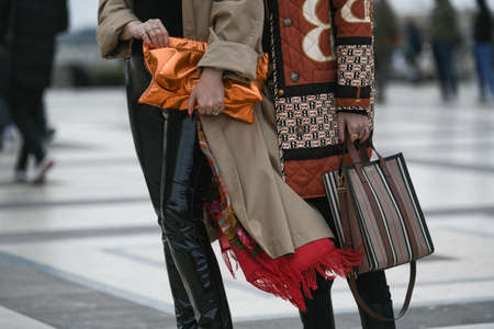 Paris, France - February 29, 2020: Neon orange clutch bag and striped Burberry handbag - streetstylefw20のeditorial素材