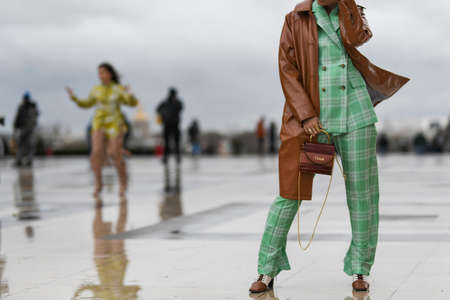 Paris, France - February 27, 2020: Woman wearing a two piece tartan set, a brown leather coat and a Chloe handbag - streetstylefw20のeditorial素材