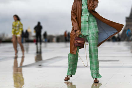 Paris, France - February 27, 2020: Woman wearing a two piece tartan set, a brown leather coat and a Chloe handbag - streetstylefw20のeditorial素材