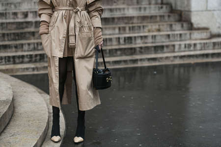 Paris, France â March 2, 2020: Woman wearing a beige trench coat, a knitted mini dress and a black leather handbag - streetstylefw20のeditorial素材