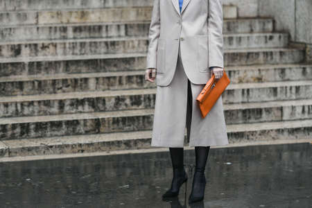 Paris, France â March 2, 2020: Woman wearing a two piece set, an orange clutch bag and black high heel pointed shoes - streetstylefw20のeditorial素材