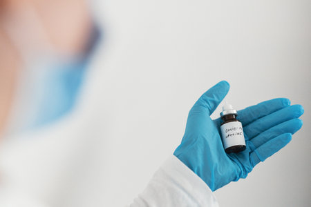 Female doctor holding in her hand coronavirus vaccine