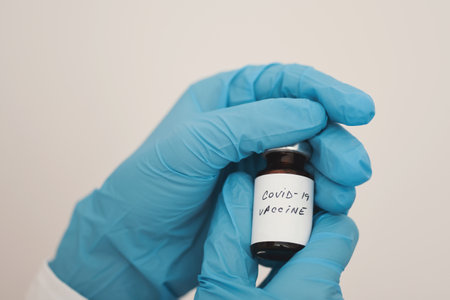 Female doctor holding in her hand coronavirus vaccineの写真素材