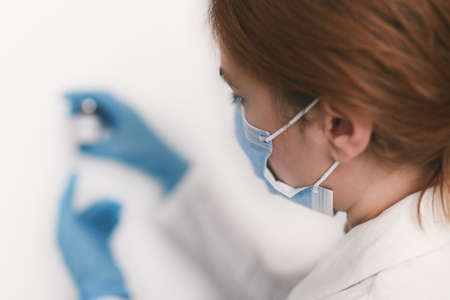Female doctor holding in her hand coronavirus vaccine - covid-19 health conceptの写真素材