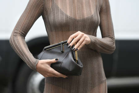 Milan, Italy - September 22, 2021:  Street style outfit, fashionable woman wearing leopard print pattern vintage sunglasses, a gold Fendi hair clip, a beige cut-out turtlenekc / long sleeves / fringed knees dress, black underwear, a black shiny leather paのeditorial素材