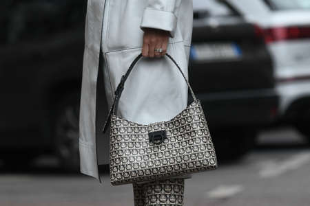 Milan, Italy - September 22, 2021:  Street style outfit, fashionable woman wearing creme white coat,...