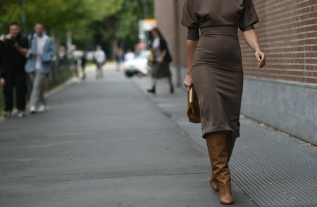 Milan, Italy - September 22, 2021:  Street style outfit, fashionable woman wearing leopard print pattern vintage sunglasses, a gold Fendi hair clip, a beige cut-out turtlenekc / long sleeves / fringed knees dress, black underwear, a black shiny leather paのeditorial素材