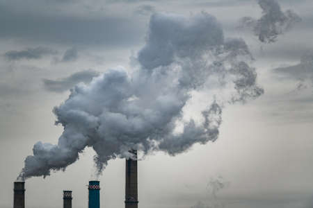 Air pollution concept - smoke from chimneys of power plantの写真素材