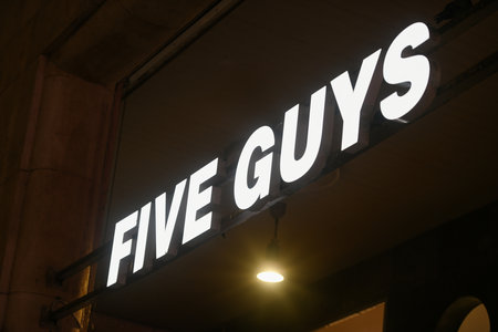 Milan, Italy - September 24, 2021: Five Guys logo displayed on a facade of a store in Milan.のeditorial素材