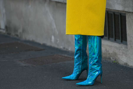 Street style outfit - woman wearing neon blue high heel boots and yellow coat