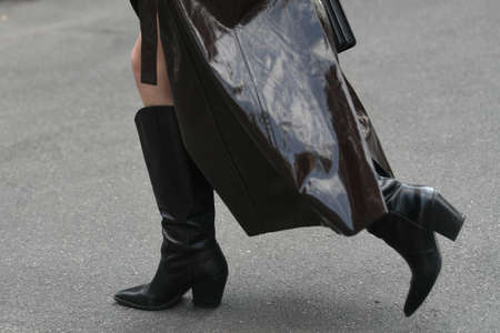 Street style outfit - woman wearing shiny dark brown coat, black handbag and boots