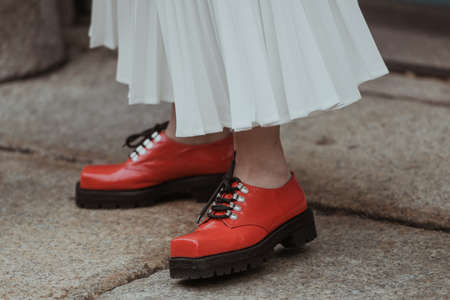 Street style outfit - woman wearing long white dress and red shoesの写真素材