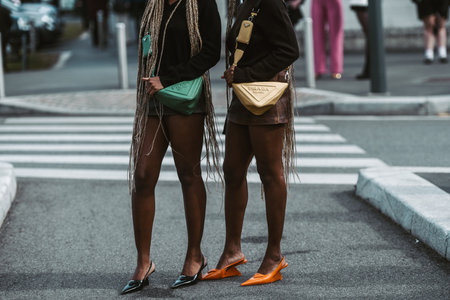 MILAN, ITALY - FEBRUARY 24: Street style outfit - girls wearing Prada purses and shoes.のeditorial素材