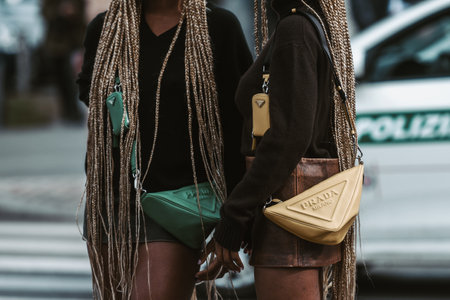 MILAN, ITALY - FEBRUARY 24: Street style outfit - girls wearing Prada purses and shoes.のeditorial素材
