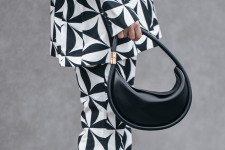 Milan, Italy - February 24, 2022: Street style, woman wearing optical black and white outfit.のeditorial素材
