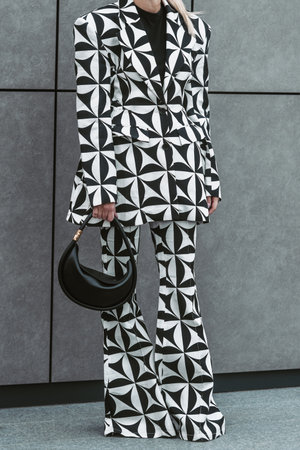 Milan, Italy - February 24, 2022: Street style, woman wearing optical black and white outfit.のeditorial素材