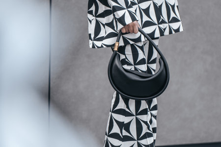 Milan, Italy - February 24, 2022: Street style, woman wearing optical black and white outfit.のeditorial素材