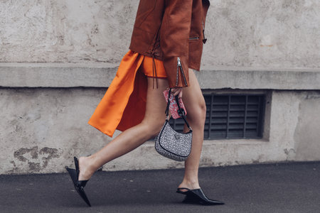 Milan, Italy - February, 24: Street style, woman wearing a black turtleneck top, orange mini skirt with train, black heels and Prada bag.のeditorial素材