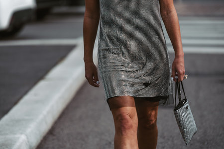 Milan, Italy - February, 24: Street style, woman wearing sleeveless short dress from Prada and silver rhinestones handbag.のeditorial素材