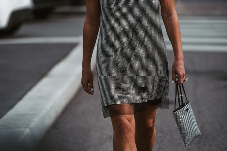 Milan, Italy - February, 24: Street style, woman wearing sleeveless short dress from Prada and silver rhinestones handbag.のeditorial素材