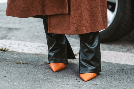 Milan, Italy - February, 24: Street style, woman wearing a brown oversized coat, black leather pants and neon orange shoes.のeditorial素材