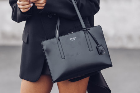 Milan, Italy - February, 24: Street style, woman wearing a black polo top, black blazer, brown mini skirt with long train, black Prada bag and black heels.のeditorial素材