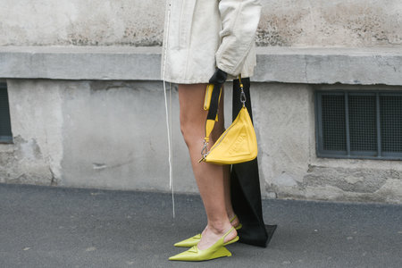Milan, Italy - February, 24: Street style, woman wearing beige leather jacket, yellow Prada bag and lime green Prada heels.のeditorial素材