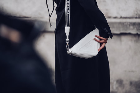 Milan, Italy - February, 24: Street style, woman wearing black coat and white Prada bag.のeditorial素材