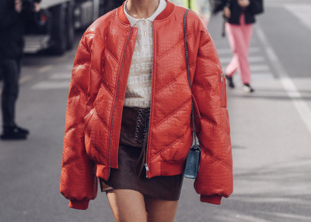 Milan, Italy - February, 24: Street style, woman wearing red shiny leather crocodile print puffer jacket.のeditorial素材