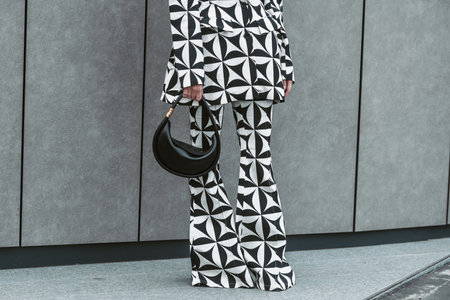 Milan, Italy - February 24, 2022: Street style, woman wearing optical black and white outfit.のeditorial素材