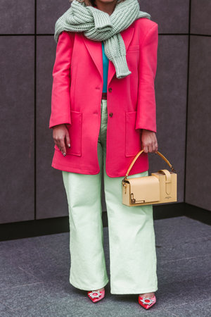 Milan, Italy - February, 24: Street style, woman wearing yellow bag, pink jacket and green pants.のeditorial素材