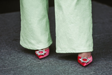 Milan, Italy - February, 24: Street style, woman wearing green pants and pink shoes.のeditorial素材