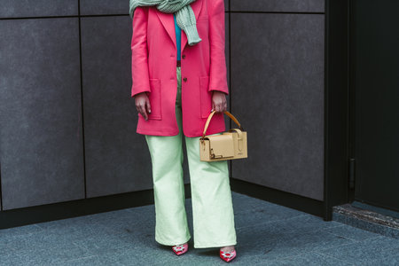 Milan, Italy - February, 24: Street style, woman wearing yellow bag, pink jacket, green pants and pink shoes.のeditorial素材