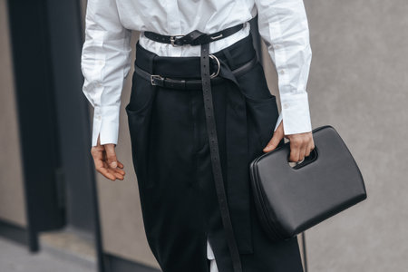 Milan, Italy - February, 24: Street style, woman wearing white V-neck shirt and black leather pants.のeditorial素材