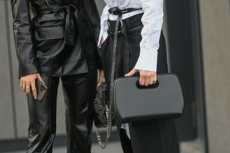 Milan, Italy - February, 24: Street style, woman wearing white V-neck shirt and black leather pants.のeditorial素材