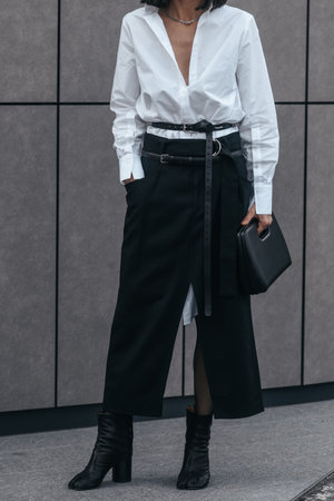 Milan, Italy - February, 24: Street style, woman wearing white V-neck shirt and black leather pants.のeditorial素材