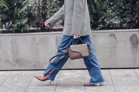 Milan, Italy - February, 24: Street style, woman wearing a blue striped print pattern with embroidered sequined oversized jacket, high waist pale blue wide legs pants.のeditorial素材