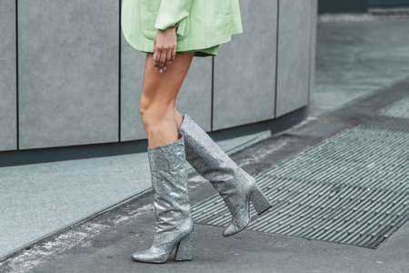 Street style, woman wearing neon green cardigan and shorts, matching neon green blazer jacket and heels knees boots.のeditorial素材