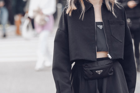 Milan, Italy - February, 24: Street style, woman wearing denim jacket, a high waist black midi skirt, a black handbag from Prada, black socks, black pointed pumps heels shoes.のeditorial素材