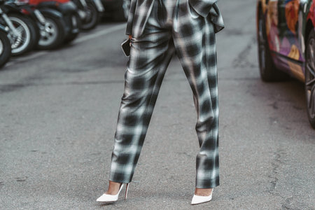 Milan, Italy - February 25, 2022: Crop female in stylish checkered suit in Milan, Italy.のeditorial素材