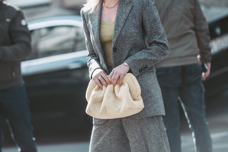 Milan, Italy - February 25, 2022: Female in stylish gray suit with yellow lime top with bag in Milan, Italy.のeditorial素材