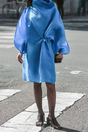 Milan, Italy - February 25, 2022: Women model in blue silk dress standing on crosswalk on streetのeditorial素材