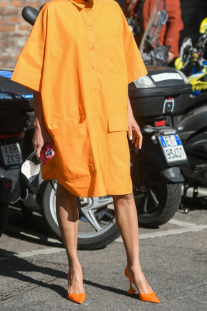 Milan, Italy - February 25, 2022:Crop anonymous female model in orange dress and high heels.のeditorial素材