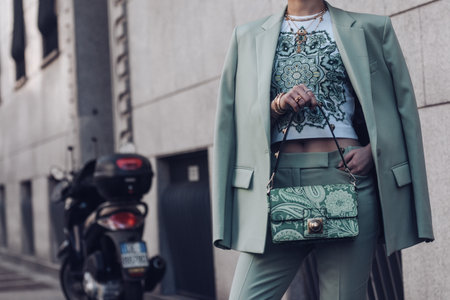 Milan, Italy - February 25, 2022: Female wearing a light green blazer, ornamental shirt and matching ornamental handbag.のeditorial素材