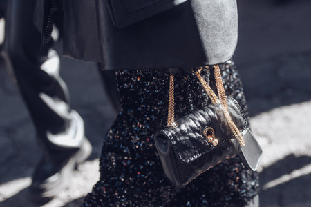 Milan, Italy - February 26, 2022: Female wearing a black glitter dress and black purse white golden lace.のeditorial素材
