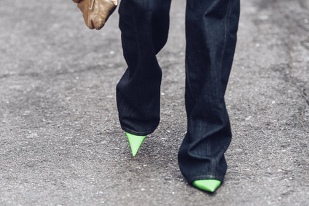 Milan, Italy - February 24, 2022: Woman wearing long dark jeans light green high heels and ornamental jacket.のeditorial素材
