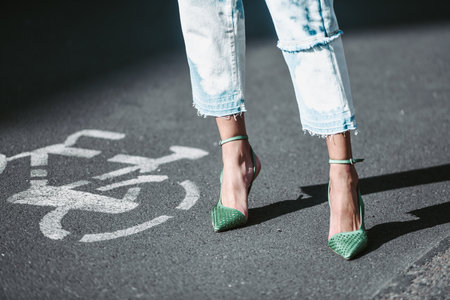 Milan, Italy - February 25, 2022: Woman in stylish jeans and green stiletto heels.のeditorial素材