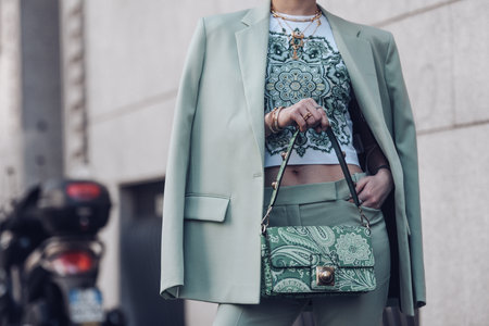 Milan, Italy - February 25, 2022: Female wearing a light green blazer, ornamental shirt and matching ornamental handbag.のeditorial素材